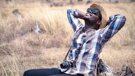 African man photographer traveling in the dry field.