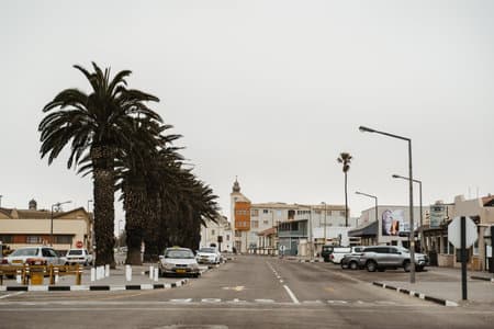 Old German colonial buildings and streets of Swakopmund, a town city in Namibia, dusty grey weather with clouds in sky