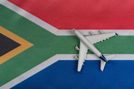 National flag of Republic of South Africa and toy airplane close up. Resumption of flights after quarantine