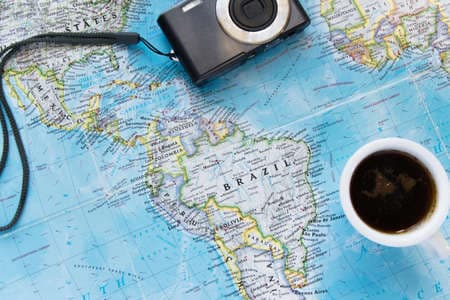 Top view of adventure flat lay with coffee cup and camera. Explore the new world or planing the vacation